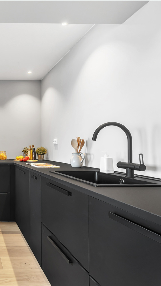 Sort kjøkkenbenk med sort vannkran av MSH Bygg